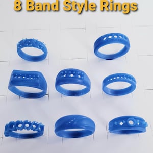 May include: Eight blue band-style rings are displayed on a white surface. The rings vary in design, with some featuring textured surfaces, while others have decorative cutouts or patterns. The text "8 Band Style Rings" is at the top.