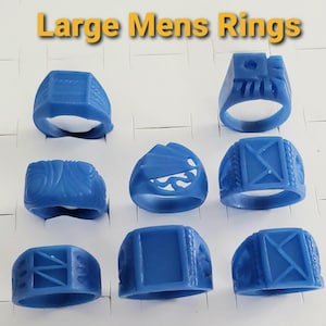 May include: A collection of nine blue rings, each with a unique design, displayed on a white surface. The rings vary in shape and texture, with some featuring geometric patterns and others with carved details. The text "Large Mens Rings" is at the top.