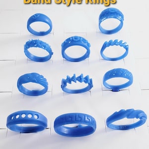May include: A collection of eleven blue wax band style rings arranged in rows. The rings feature various textures and patterns, including geometric shapes, wavy lines, and cutouts. The text "Band Style Rings" is displayed at the top of the image.