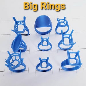 May include: A collection of nine blue wax ring models for jewelry casting, arranged in a grid. The set includes various ring settings with prongs and a solid band, all featuring the text Big Rings in yellow letters at the top of the image.