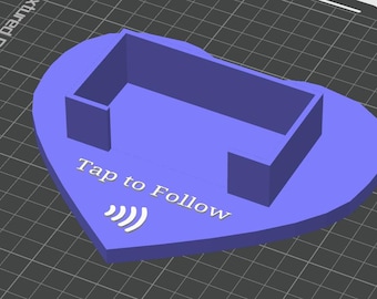Op de afbeelding: Een paars, hartvormig 3D-geprint object met een rechthoekige structuur en de tekst "Tap to Follow" met een Wi-Fi-symbool. Het object is waarschijnlijk een decoratief of functioneel item.