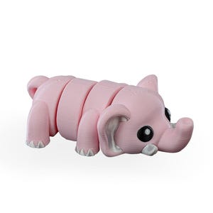 May include: A light pink, segmented elephant toy with black eyes and white accents. The toy is designed with a cute, cartoonish aesthetic, and is lying down. The elephant's trunk is curled, and its feet have a textured appearance.