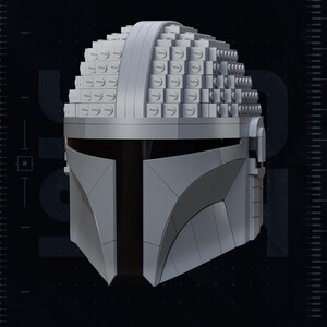 May include: A gray Mandalorian helmet constructed from stacked, square blocks, with a smooth, curved visor. The helmet's design is detailed, with visible seams and a textured surface. The image includes the text "2020" and "TEST PRINTED AMS COLORED STL".