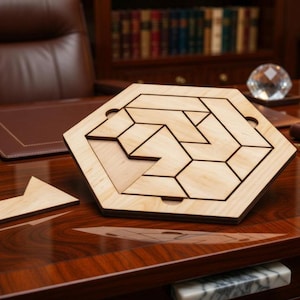 Op de afbeelding: Een houten puzzel met een zeshoekig frame en geometrische vormen. De puzzel is gemaakt van lichtgekleurd hout met donkere lijnen die de vormen definiëren. Eén stuk ligt apart, naast de puzzel op een gepolijst houten oppervlak.