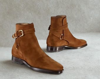 Botas Jodhpur artesanais em camurça: tira no tornozelo marrom com fivela dourada.