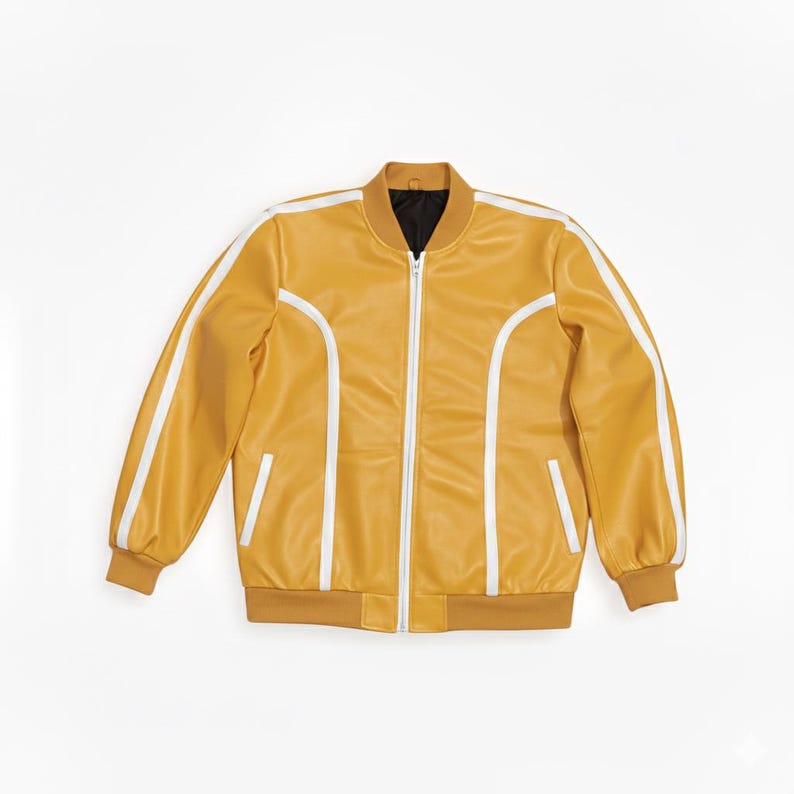 Peut inclure: Veste de bombardier jaune moutarde avec des rayures blanches sur les manches et sur les c&ocirc;t&eacute;s. La veste a une fermeture &eacute;clair sur le devant, deux poches avant et une doublure int&eacute;rieure noire. Le col et les poignets sont d'une nuance plus fonc&eacute;e de jaune moutarde.