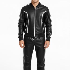 Peut inclure: Ensemble de surv&ecirc;tement en cuir noir avec des rayures blanches. La veste zipp&eacute;e pr&eacute;sente des bordures blanches. Le pantalon assorti a une taille &agrave; cordon et des rayures blanches. Un design moderne et &eacute;l&eacute;gant.