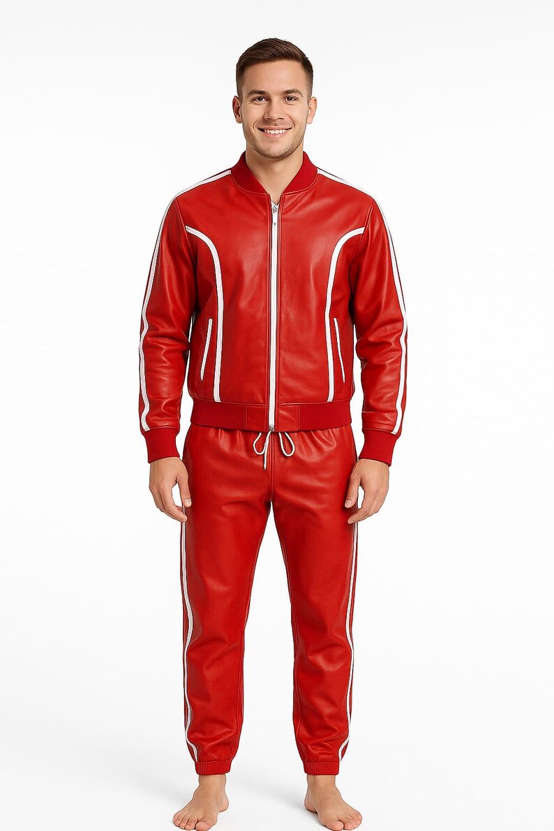 Peut inclure: Ensemble de surv&ecirc;tement en cuir rouge avec des rayures blanches. La veste a une fermeture &eacute;clair et un col de style bombardier. Le pantalon a une taille &agrave; cordon et une coupe droite. Port&eacute; par une personne.