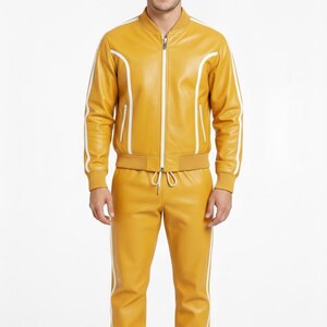 Peut inclure: Ensemble de surv&ecirc;tement en cuir jaune moutarde avec des rayures blanches. La veste a une fermeture &eacute;clair et des bordures blanches. Le pantalon a une taille &agrave; cordon et des poignets &eacute;lastiques. V&ecirc;tement de sport assorti.