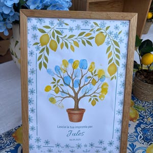 Peut inclure: Un cadre en bois clair contenant une impression d'arbre avec des feuilles d'empreintes digitales jaunes et bleues. Le cadre est orné de citrons et de fleurs, avec le texte "Lascia la tua impronta per Jules 06.09.2025".