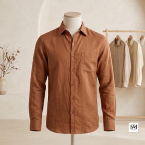 May include: A long-sleeved button-down shirt in a solid rust-brown color. The shirt features a classic collar, a single chest pocket on the left side, and matching brown buttons down the front placket. The fabric has a visible, slightly textured weave.