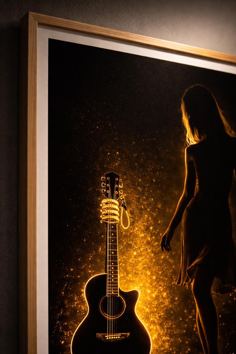 May include: Acoustic guitar art print. The black guitar is illuminated with golden light, with a woman's silhouette in the background. The guitar's headstock is wrapped in a string of lights. The artwork is framed in a light wood frame.