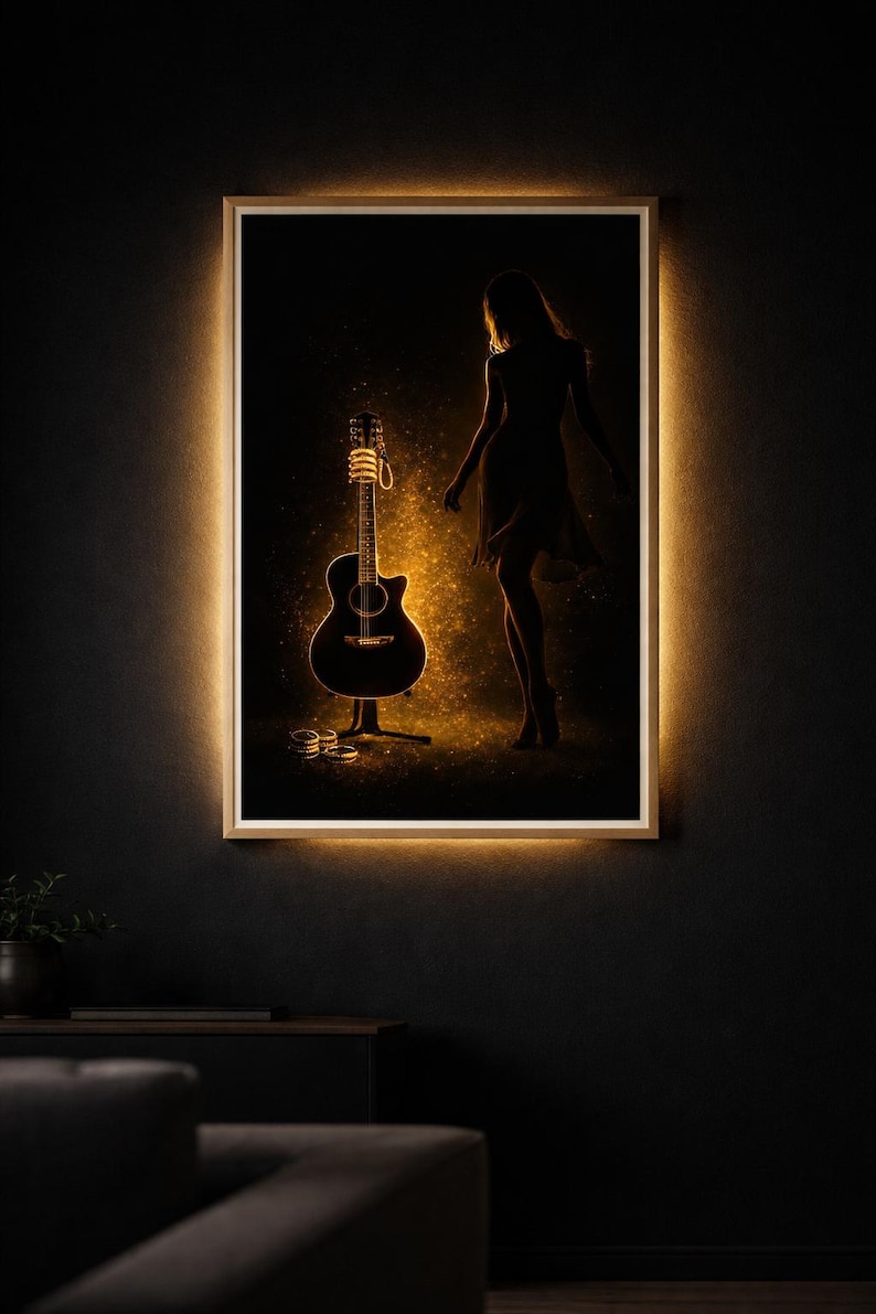 May include: Acoustic guitar art print with a silhouette of a person. The guitar is illuminated with a warm glow, set against a dark background. The artwork is framed with a light border, creating a striking visual.