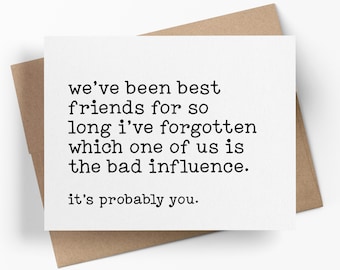 May include: A white rectangular greeting card with black typewriter-style text that reads: we’ve been best friends for so long i’ve forgotten which one of us is the bad influence. it’s probably you. The card is placed on a brown paper envelope.