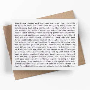 May include: A white rectangular greeting card with black typewriter-style text featuring a long, apologetic message. The card is placed on top of a plain brown envelope. The text begins with 'look. i know i fucked up. i don't need the recap'.