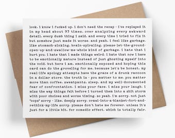 May include: A white rectangular greeting card with black typewriter-style text featuring a long, apologetic message. The card is placed on top of a plain brown envelope. The text begins with 'look. i know i fucked up. i don't need the recap'.