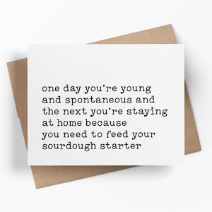 May include: A white greeting card with the text "one day you're young and spontaneous and the next you're staying at home because you need to feed your sourdough starter" is placed on a brown envelope.