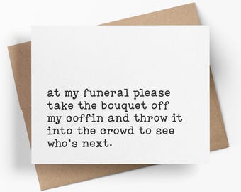 May include: A white rectangular greeting card with black typewriter-style text that reads: at my funeral please take the bouquet off my coffin and throw it into the crowd to see who's next. The card is placed on top of a brown paper envelope.