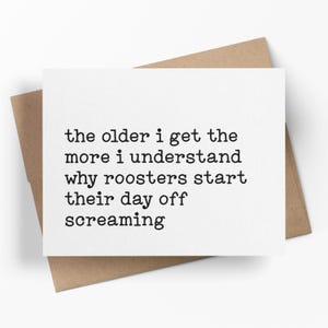 May include: A white greeting card with black text that reads "the older i get the more i understand why roosters start their day off screaming." The card is on a brown envelope.