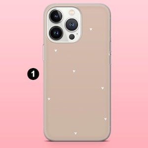 May include: A clear phone case with a tan background and small white heart patterns. The case has a camera cutout and is designed to fit a smartphone. The case is made of a clear material and has a smooth finish.
