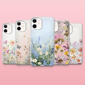 Op de afbeelding: Vijf doorzichtige smartphonehoesjes op een rij, elk met een uniek bloemendesign. De ontwerpen bevatten diverse wilde bloemen, madeliefjes en vlinders in zachte pastelkleuren zoals blauw, roze, geel en wit, gedrukt op transparante covers.