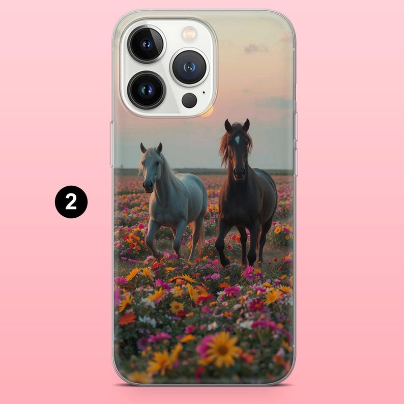 May include: A phone case with an image of two horses galloping through a field of colourful wildflowers. One horse is white, the other is dark brown, set against a sunset sky.