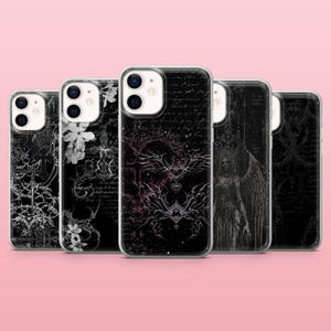 Peut inclure: Plusieurs coques de téléphone noires avec des motifs d'inspiration gothique. Les coques présentent des illustrations de croix, d'ailes d'ange, de motifs floraux et d'écritures. Les coques sont présentées sur un fond rose.
