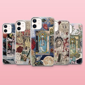 May include: A collection of phone cases featuring tarot card designs. Each case displays a unique collage of imagery, including illustrations of figures, celestial bodies, and text. The cases have a glossy finish and are arranged against a pink background.