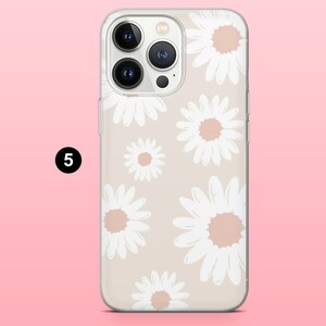 May include: Clear phone case with a daisy pattern. The case features a beige background with white daisies and peach-colored centers. The phone case is designed to fit a smartphone.
