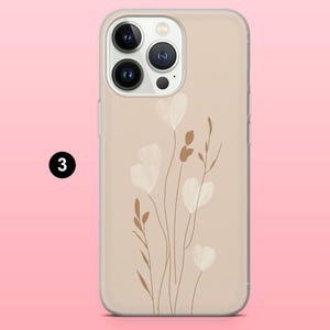 May include: A beige phone case featuring a floral design. The case has a clear border and a pattern of white, heart-shaped flowers and brown stems. The number 3 is in a black circle in the upper left corner.