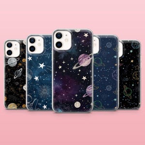 May include: A collection of five phone cases with space-themed designs. Each case features a different cosmic pattern, including planets, stars, and galaxies in shades of blue, purple, and gold. The cases are made of a clear, protective material.