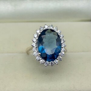 Fine jewelry ring featuring a lab-created blue sapphire surrounded by brilliant white stones.