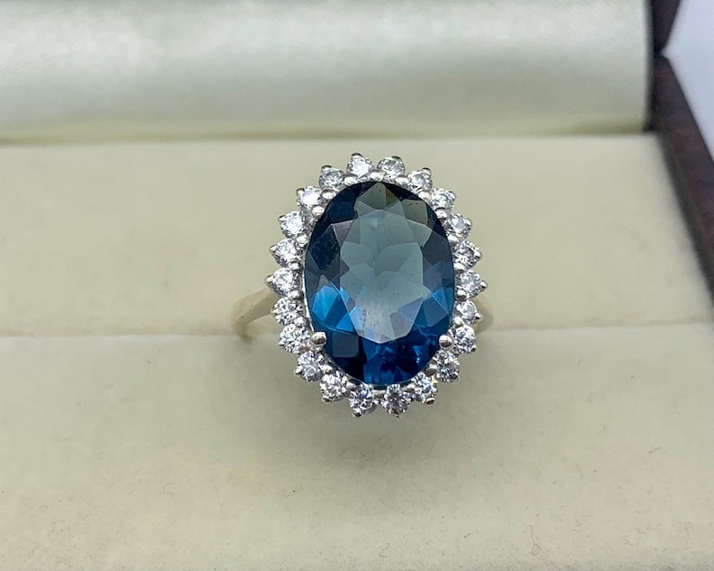 Fine jewelry ring featuring a lab-created blue sapphire surrounded by brilliant white stones.