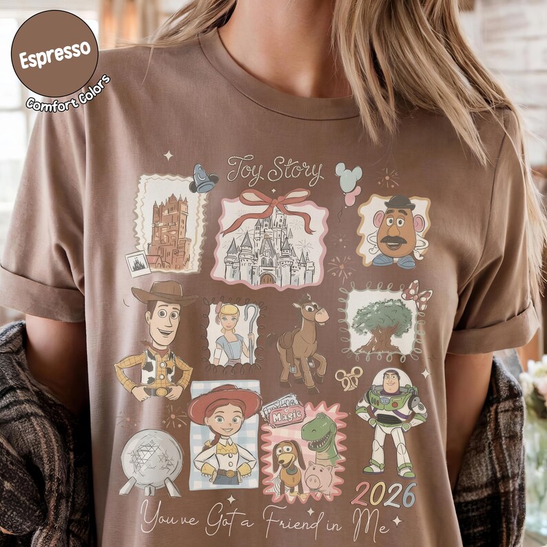 May include: Espresso-colored t-shirt featuring a collage of Toy Story characters and imagery. The design includes Woody, Buzz Lightyear, and other characters in a postage stamp style. Text includes "Toy Story" and "You've Got a Friend in Me."