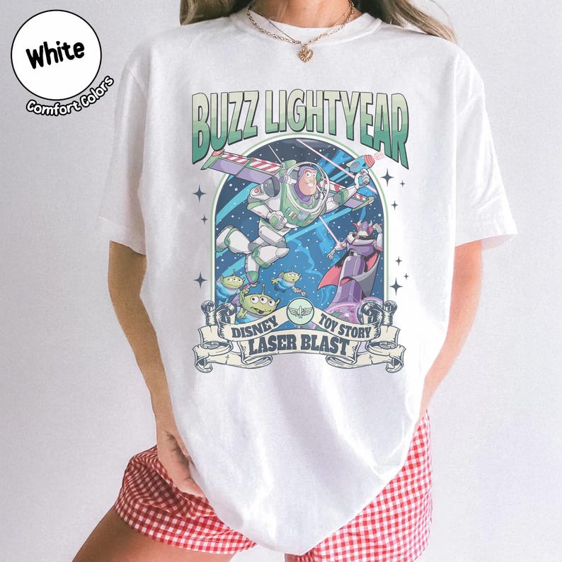 Puede incluir: Camiseta blanca con un gr&aacute;fico de Buzz Lightyear de Toy Story de Disney. El dise&ntilde;o incluye a Buzz con su traje espacial, extraterrestres y el texto "Buzz Lightyear" y "Laser Blast". La camiseta est&aacute; etiquetada como "Comfort Colors".