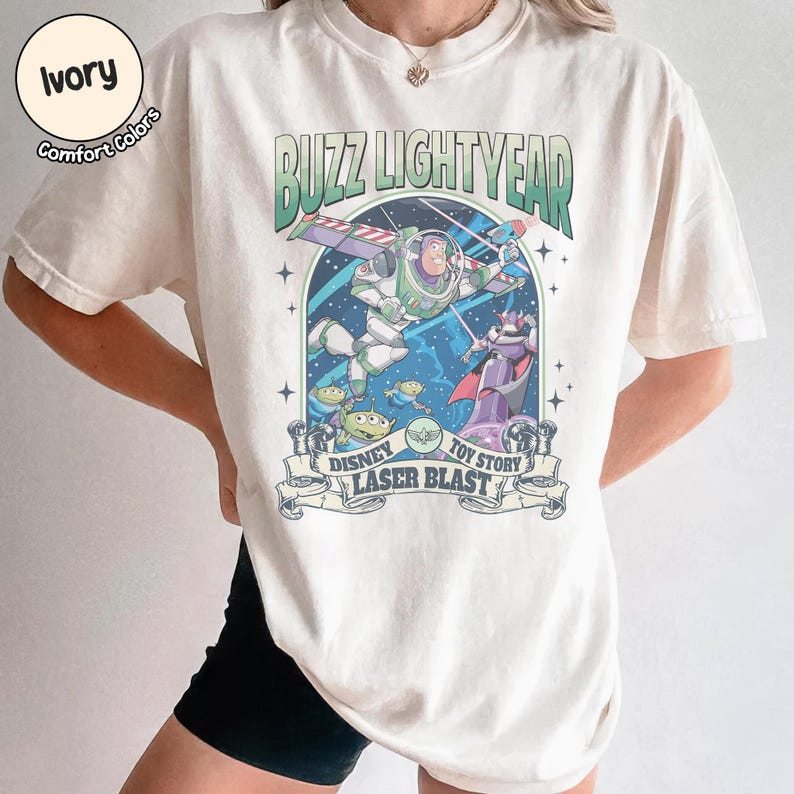 Puede incluir: Camiseta de color marfil con un gr&aacute;fico de Buzz Lightyear de Toy Story. El dise&ntilde;o incluye el texto "Buzz Lightyear", "Disney" y "Laser Blast". La camiseta tiene cuello redondo y mangas cortas.