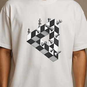 May include: An off-white short-sleeve t-shirt featuring a black and white graphic print of an impossible triangle shape constructed from a checkered chessboard pattern, with various chess pieces positioned along the edges of the geometric structure.