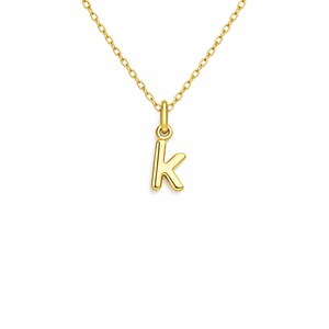 May include: A gold-colored necklace featuring a small pendant in the shape of the letter "K". The pendant and chain are both a bright, shiny gold. The chain is delicate and appears to be made of small, connected links.