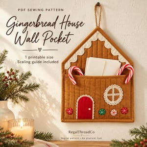 May include: A brown quilted fabric wall pocket shaped like a gingerbread house with a red door, white lace trim, and candy cane accents. Text reads: PDF SEWING PATTERN Gingerbread House Wall Pocket, 1 printable size, Scaling guide included, RegalThreadCo.