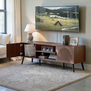May include: A dark brown wooden TV stand in a mid-century modern style. It features a cabinet door, open shelving, and a slatted door. A lamp with an owl-shaped base is on top. The stand is set on a beige carpet in a living room.