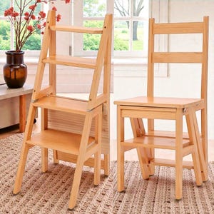 Könnte beinhalten: Zwei Holztrittleitern. Eine ist eine zusammenklappbare Trittleiter mit drei Stufen. Die andere ist ein Stuhl mit einem Trittleiterfuß. Beide sind aus hellem Holz und für den Hausgebrauch geeignet.