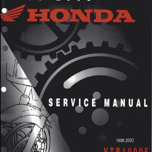 May include: A black service manual cover for a Honda VTR1000F Super Hawk motorcycle, covering years 1998-2003. The cover features red Honda branding, a graphic of mechanical gears, and a line drawing of a motorcycle front end on the left side.