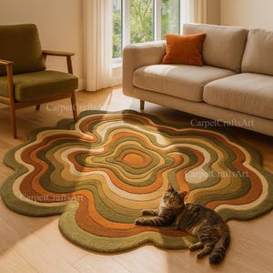 May include: A distinctive, organic-shaped rug in a living room setting. The rug has concentric layers of colour, including green, brown, and orange. A cat is lying on the rug. The rug's design evokes a retro aesthetic.