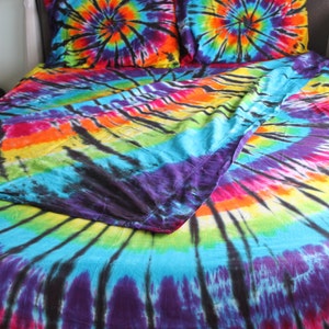 May include: A colorful tie-dye bedding set with a black background and a swirl pattern. The set includes a duvet cover and two pillowcases.