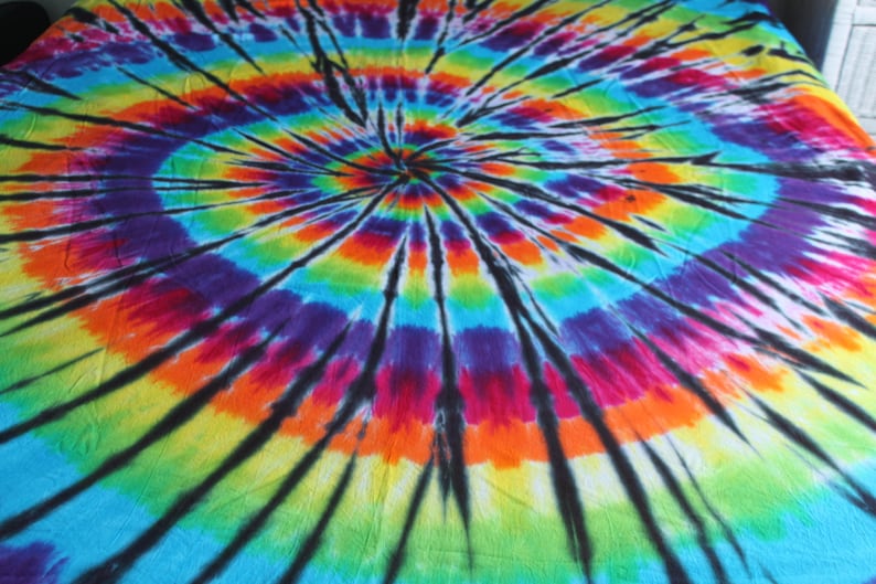 May include: A circular tie-dye pattern in shades of blue, green, yellow, orange, red, pink, and purple with black lines radiating from the center.