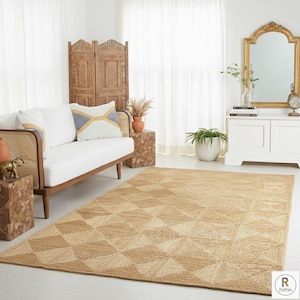 Puede incluir: Una alfombra rectangular grande de yute con un patrón geométrico de diamantes en tonos beige y marrón claro. La alfombra está colocada en un salón, complementando los tonos neutros de los muebles y la decoración. La alfombra añade textura y calidez al espacio.