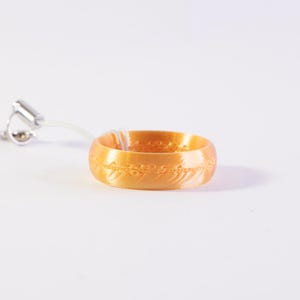 Op de afbeelding: Een witte keramische mok met een zwarte handgreep en de tekst "But First, Coffee" in een vetgedrukte, zwarte letter. De mok staat tegen een vage achtergrond, wat een gezellige setting suggereert.