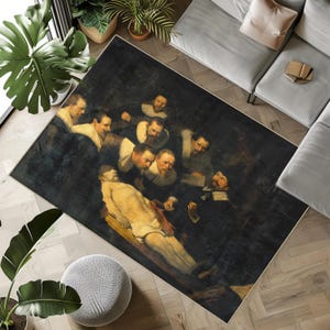 May include: Rectangular area rug featuring a dark, dramatic painting of a group of men gathered around a figure. The artwork depicts a scene with figures in dark clothing and white collars, with a central figure lying on a wooden surface. The rug has a dark background.