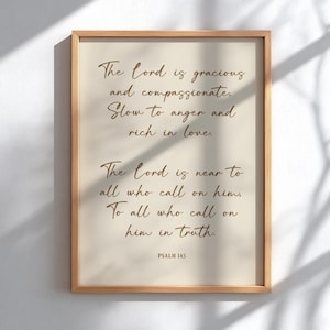 May include: A framed print with a light beige background and brown text. The text reads, "The Lord is gracious and compassionate. Slow to anger and rich in love. The Lord is near to all who call on him. To all who call on him in truth. PSALM 145."