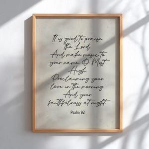 May include: A framed print with a light beige background and a wooden frame. The print features elegant black script with a religious quote from Psalm 92. The text includes phrases like "praise the Lord" and "faithfulness at night."